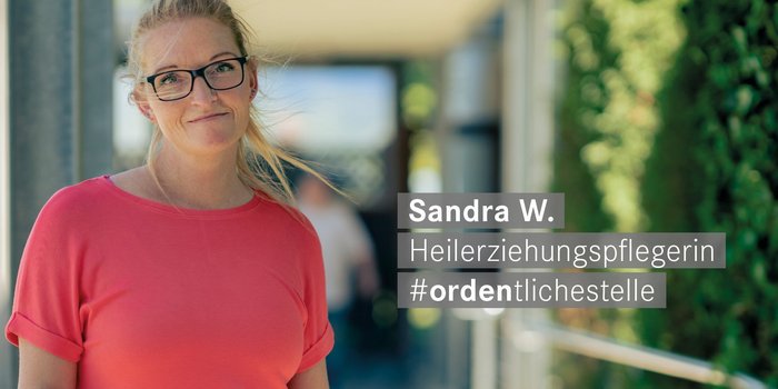 Heilerziehungspflegerin mit Brille laechelt freundlich in die Kamera